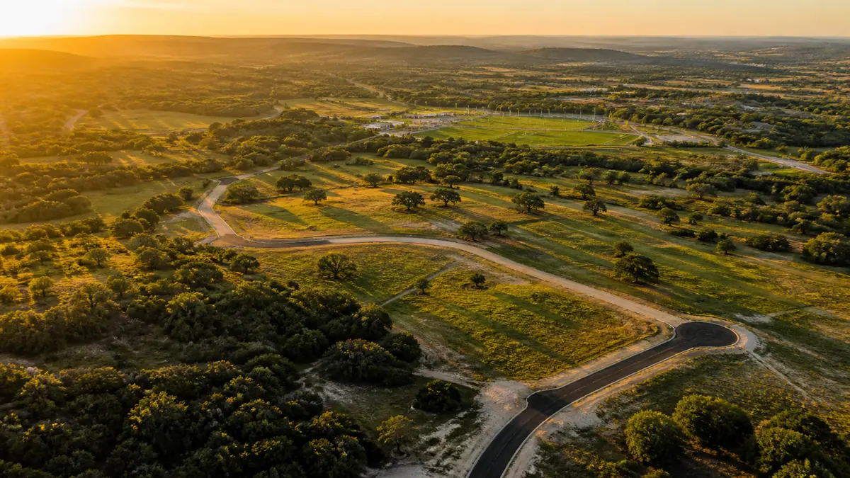 Aerial view of green Hill Country land at sunset